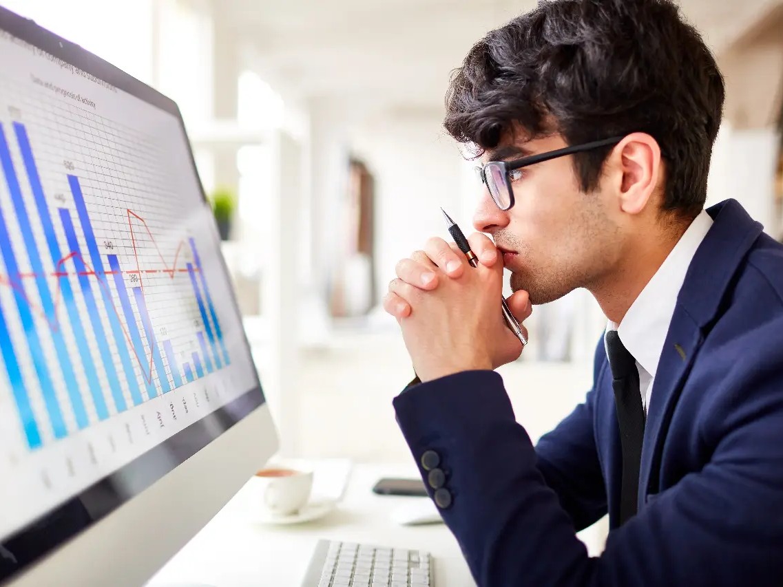 man looking at a guide - How to Get a Funded Trading Account