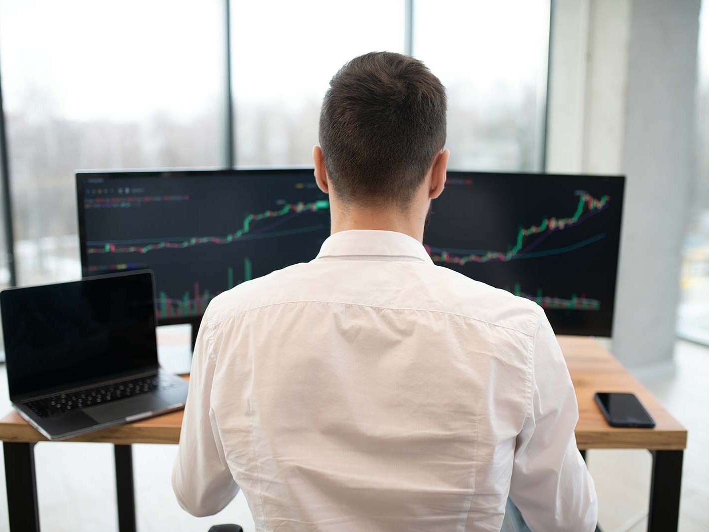 man infront of screen - How Funded Trading Accounts Work