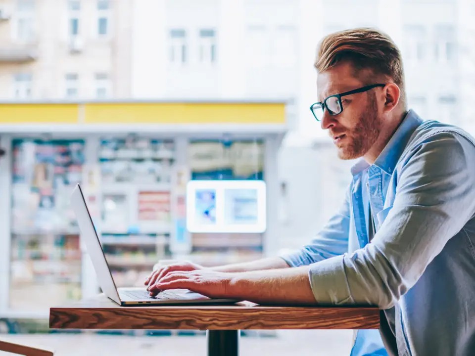 man trading in a cafe -  Best Strategy to Pass Prop Firm Challenge