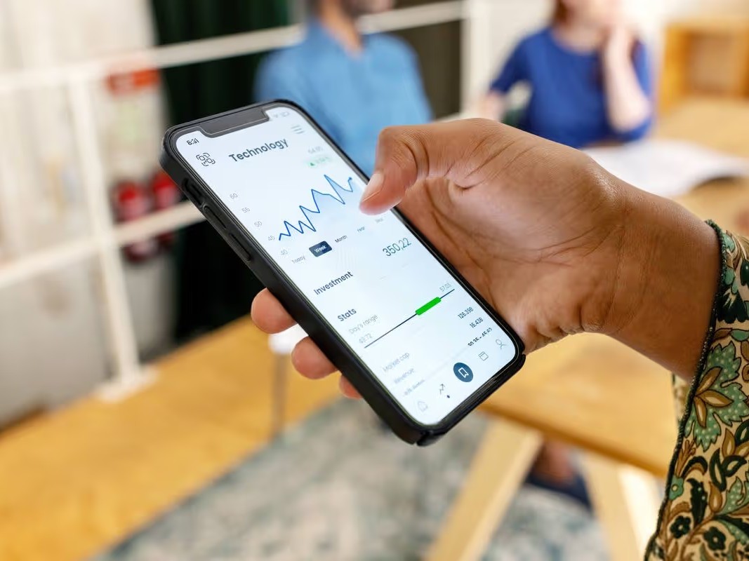 woman looking at mobile - How to Qualify for a Prop Firm Challenge